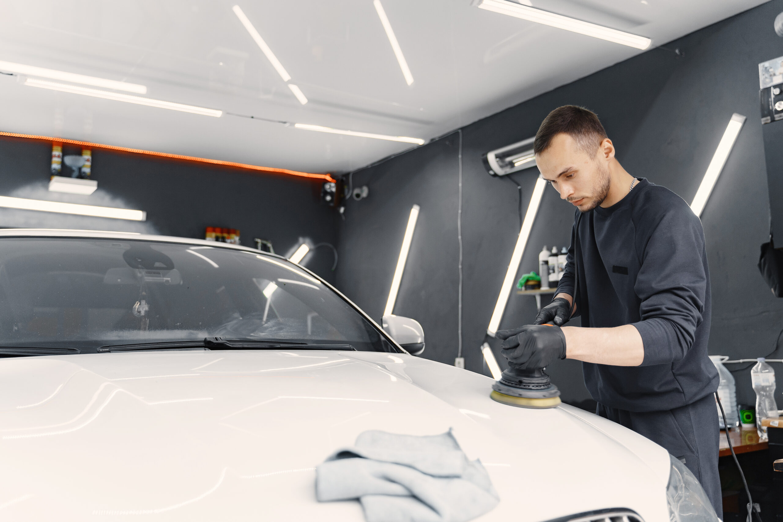 Man polish a car in a garage